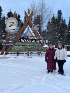 Commissioiners standing in snow in front of Waskaganish sign